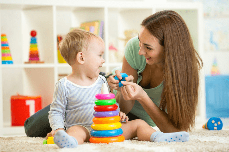 Sitter playing a board game with kids
